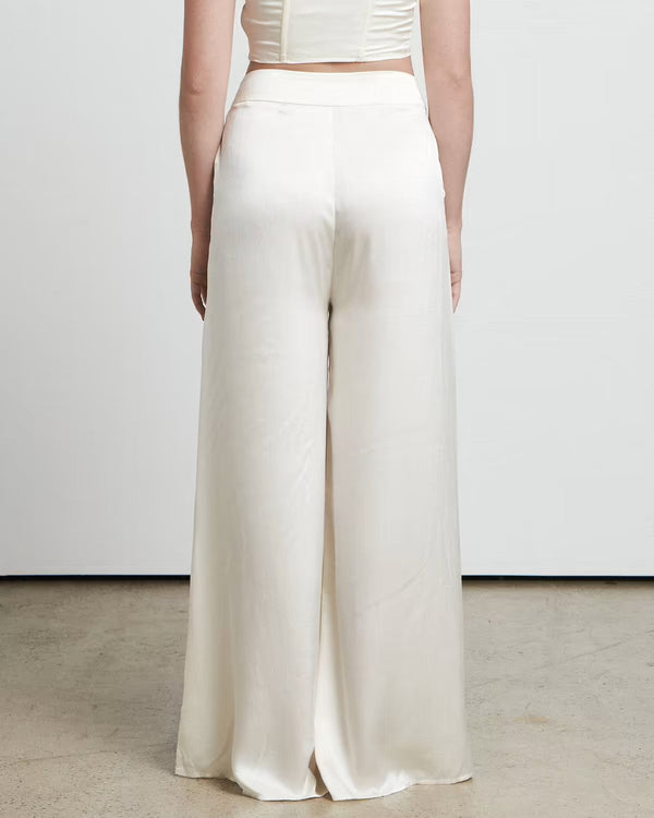 Woman wearing cream wide leg trousers styled from behind, showing the flowing silhouette from BELLA n' BEAR