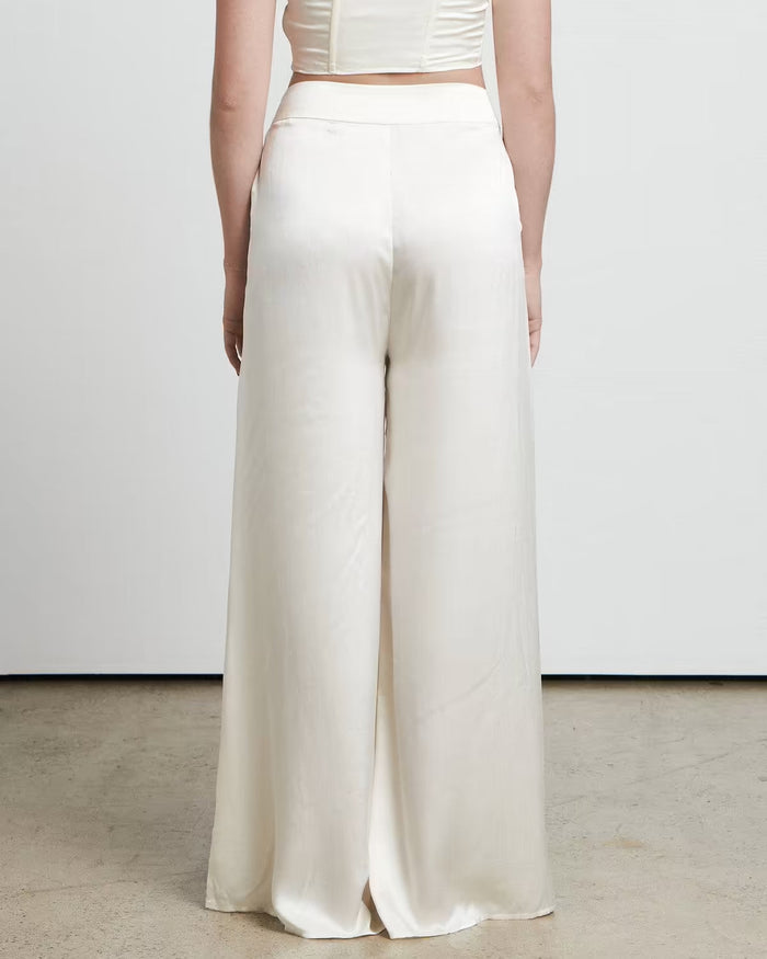 Woman wearing cream wide leg trousers styled from behind, showing the flowing silhouette from BELLA n' BEAR