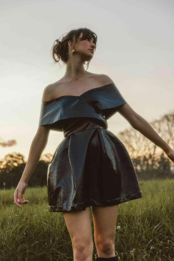 Woman wearing a black mini dress styled with heels, perfect for a birthday dinner or night out