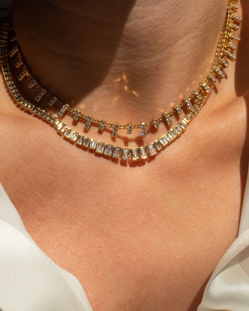 model wearing gold choker and gold tennis necklace