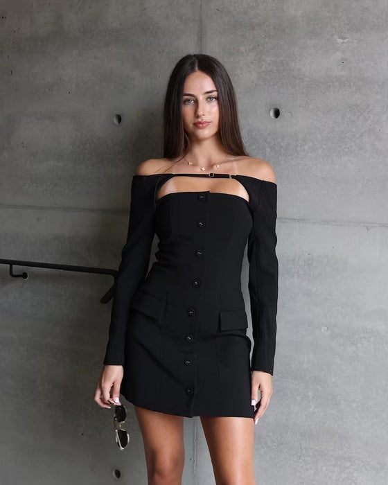 model wearing black off shoulder mini dress holding gold sunglasses