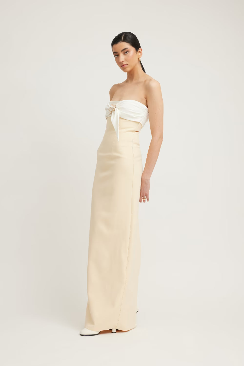 Kasai dress in cream with a strapless design and a knotted bodice, featuring a fitted maxi silhouette.