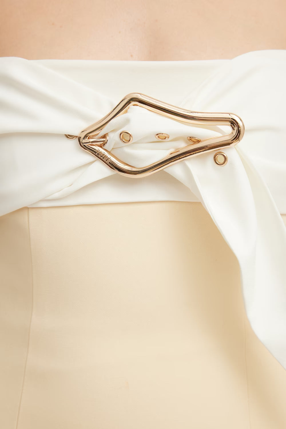 Kasai dress featuring a strapless design with a gold buckle detail and a fitted beige bodice.