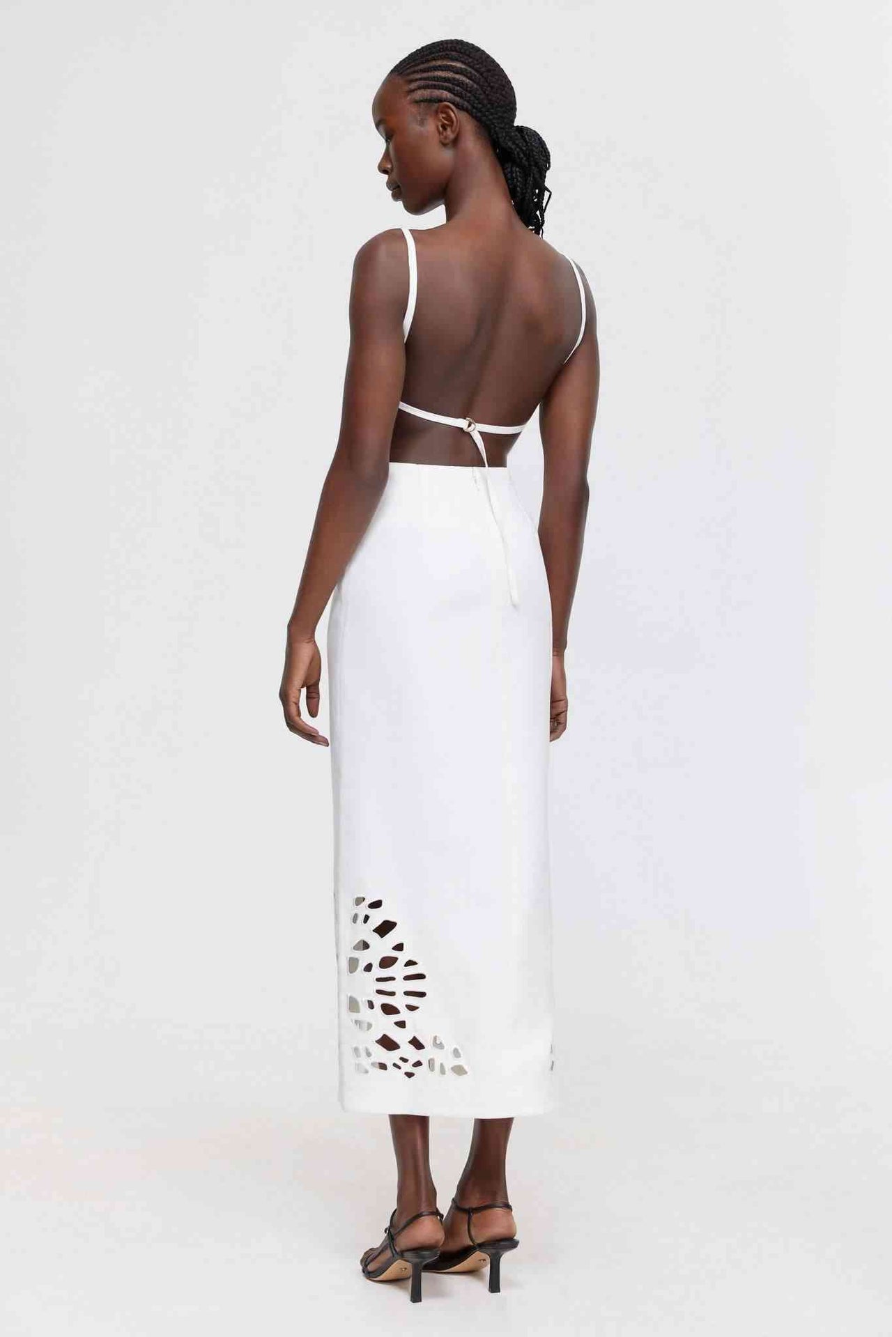 a woman wearing a white Acler Delacourt Midi Dress with cut outs