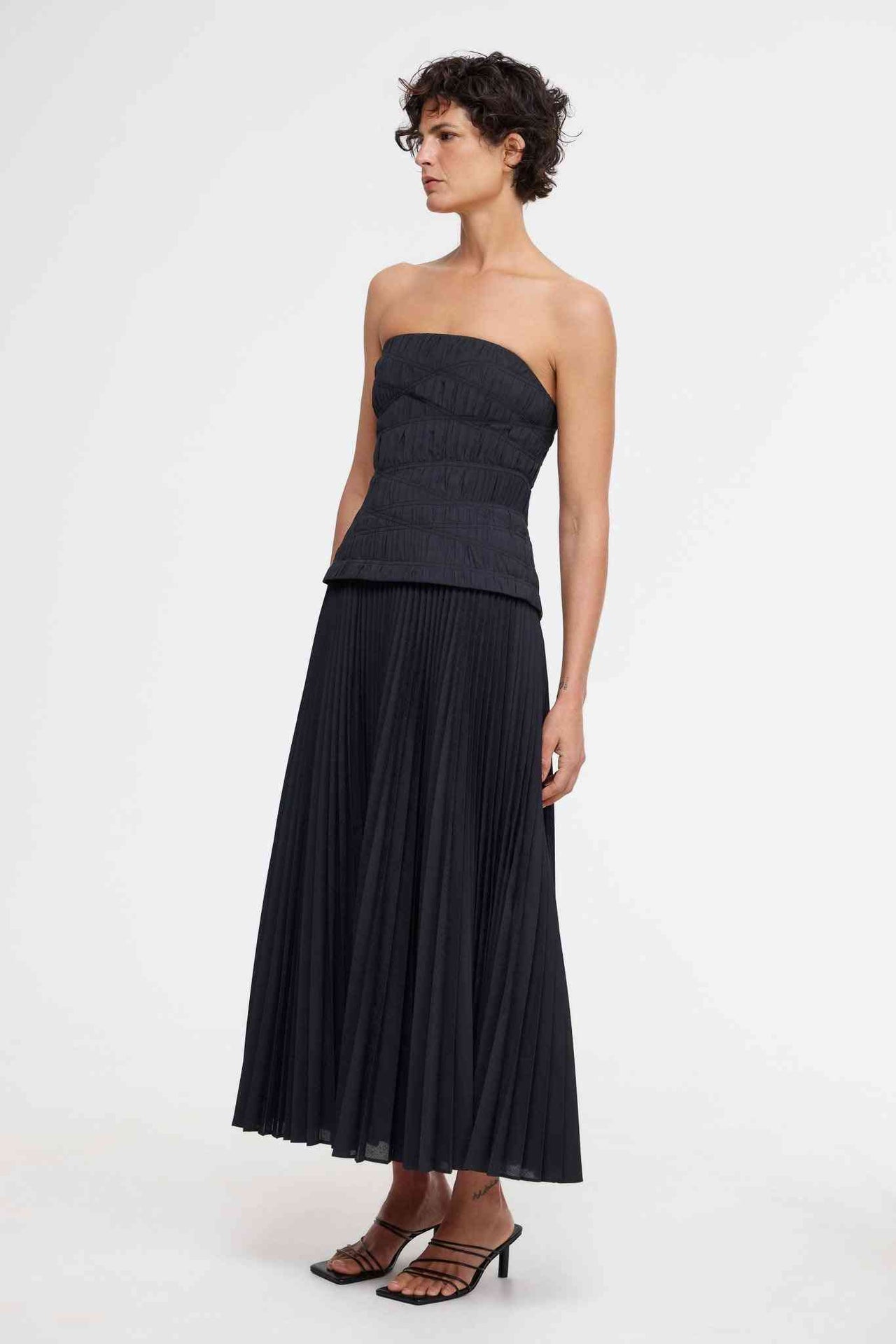 a woman in a strapless black Acler Bristol Midi Dress