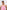 a woman in a pink By Johnny Elara midi dress posing for a picture