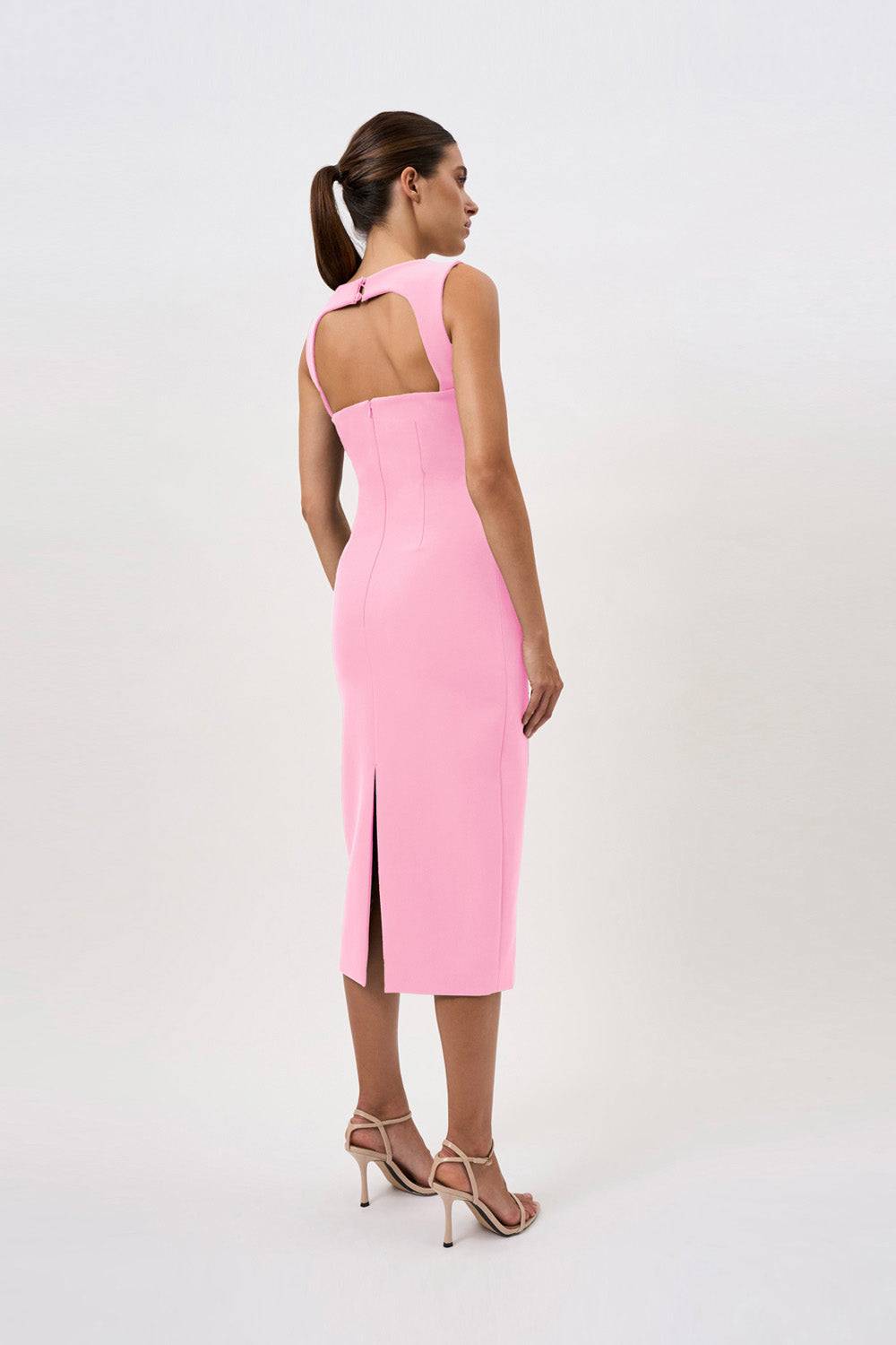 a woman in a pink By Johnny Elara midi dress with a high slit