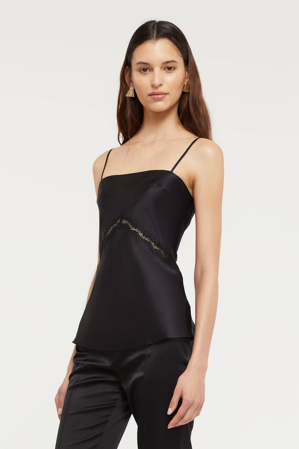Black Nomie Cami top with thin straps and lace detailing, worn by a model against a neutral background.