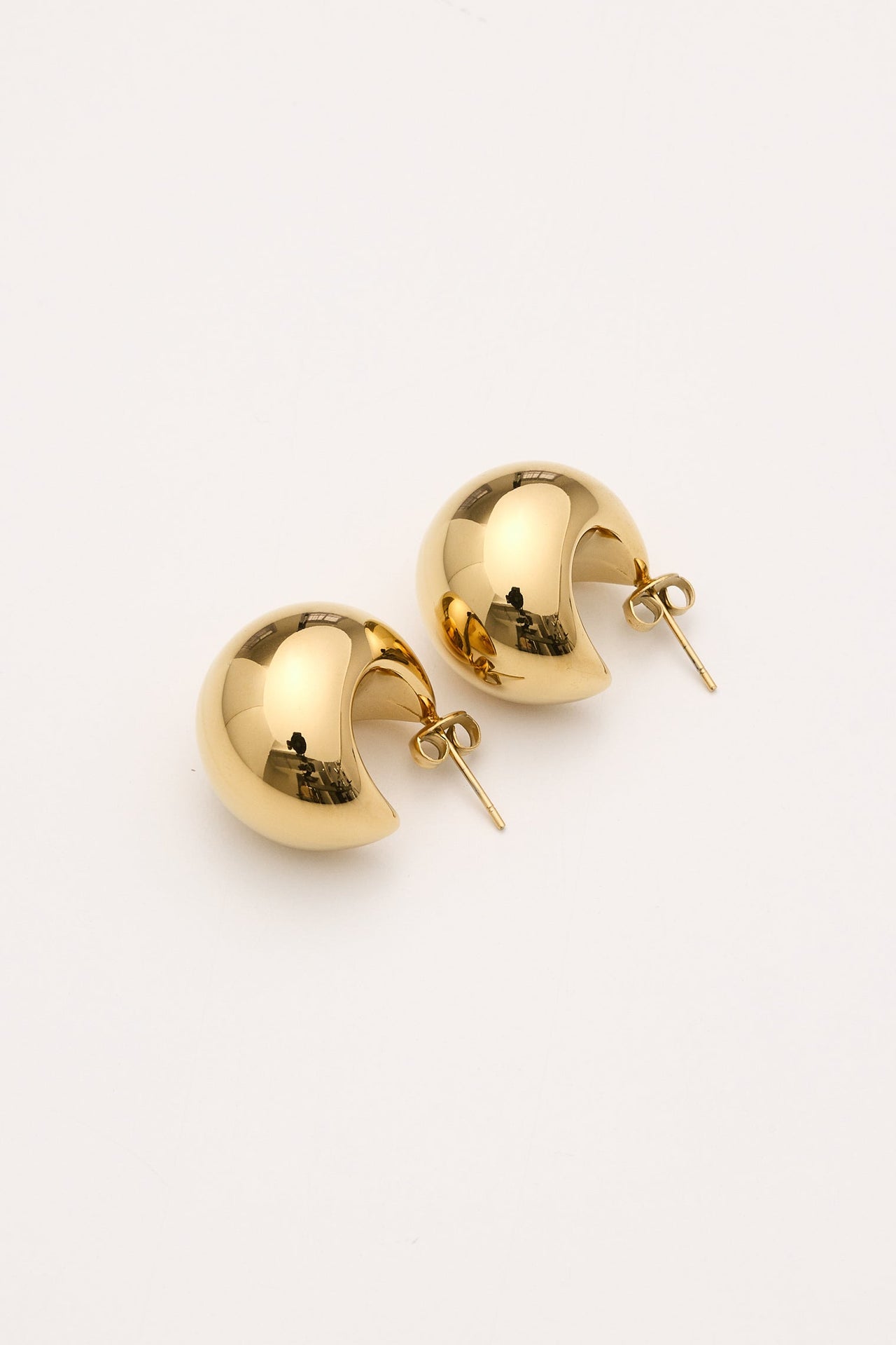 a pair of gold earrings on a white background