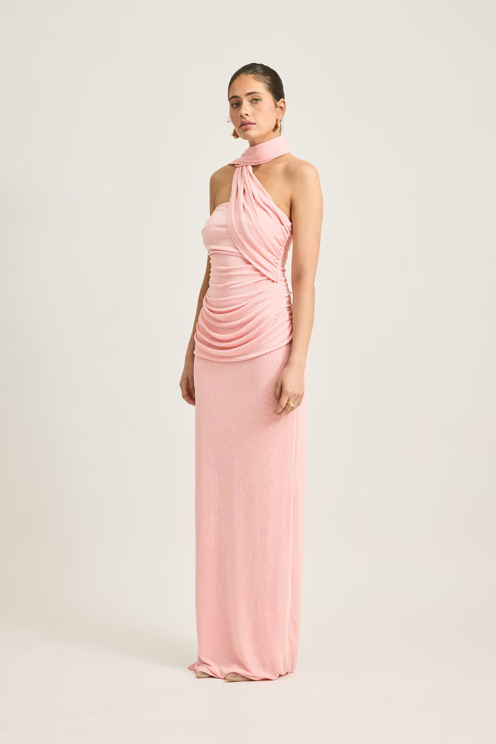 Iesha dress in soft pink, featuring a halter neck and ruched detailing, styled on a model against a neutral background.