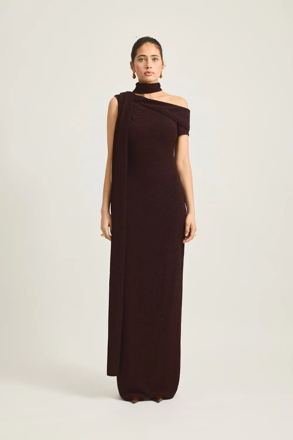 Woman wearing a brown one-shoulder dress on a white background