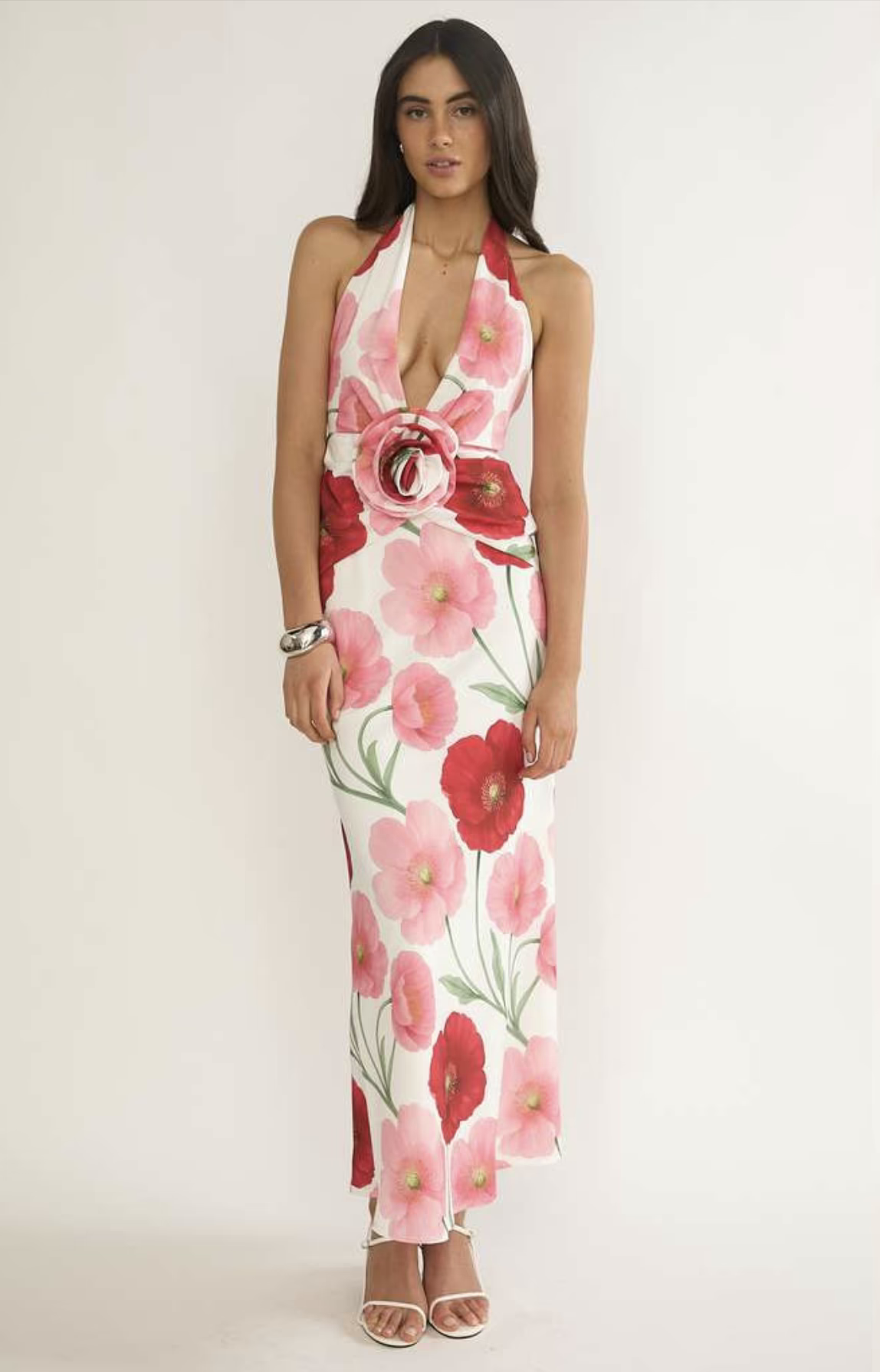 Woman wearing a floral dress with red and pink flowers on a white background
