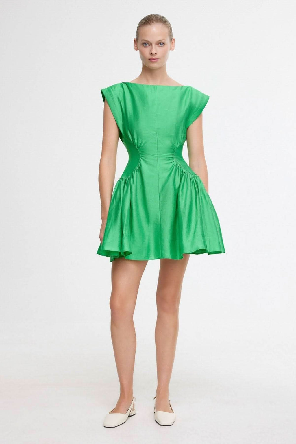 Green mini dress front view with ruched waist and flared skirt