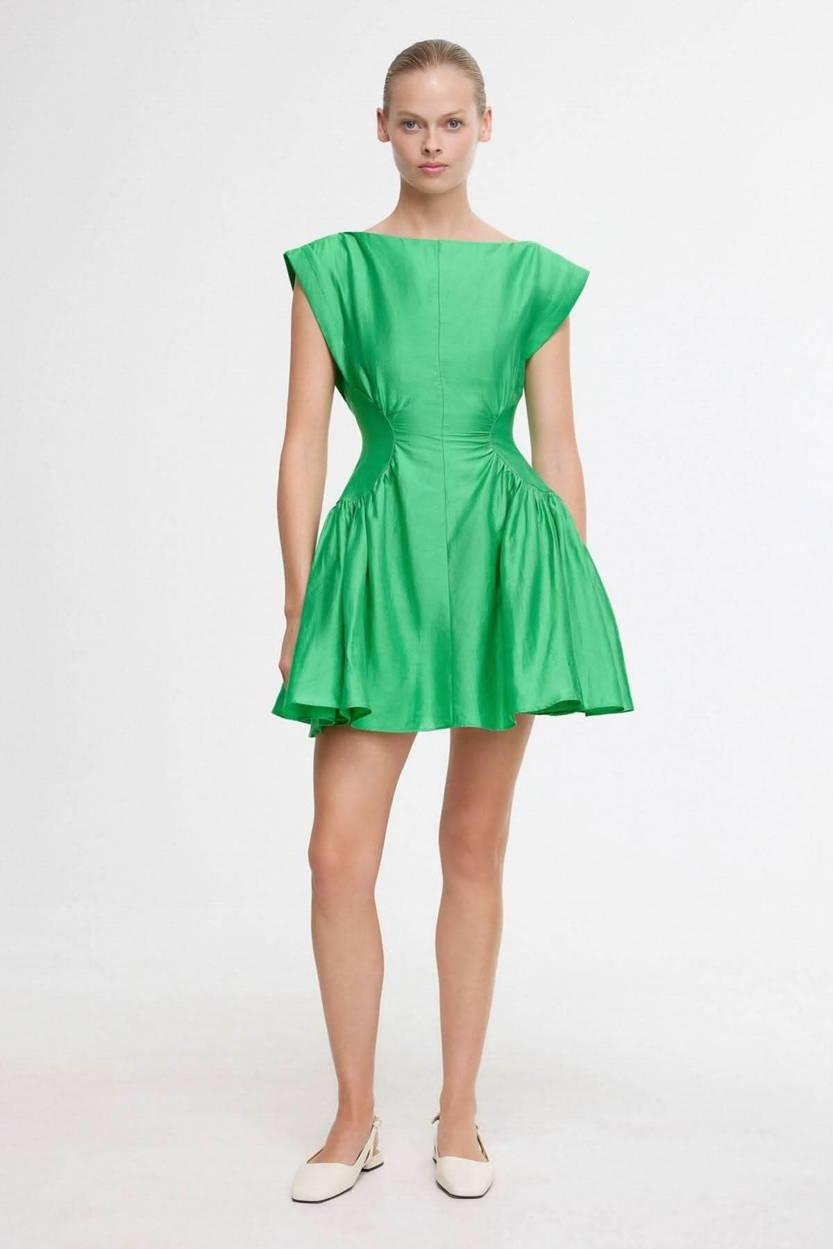 Green mini dress front view with ruched waist and flared skirt