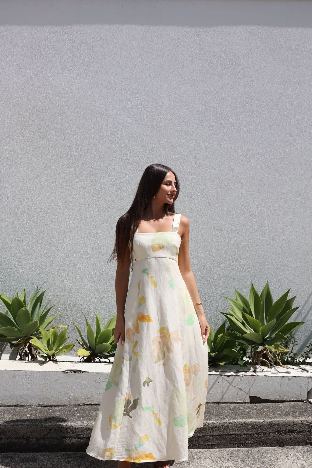 Floral midi dress with wide straps and flowing skirt, cream base with yellow-green flower print