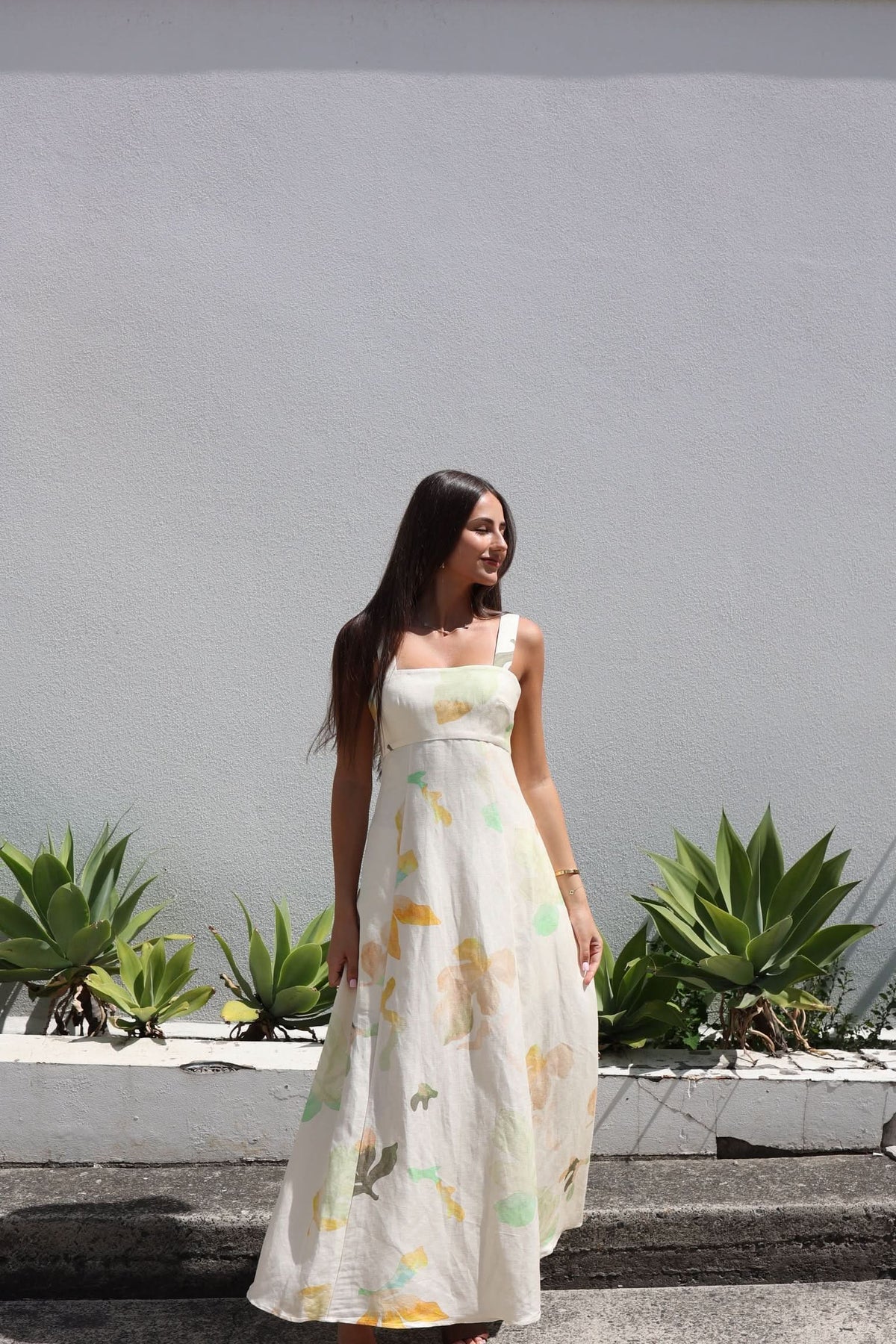 Floral midi dress with wide straps and flowing skirt, cream base with yellow-green flower print