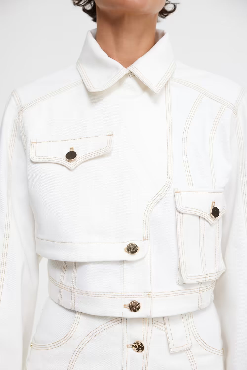 Ivory cropped jacket with pointed collar, flap pockets, and gold-tone buttons