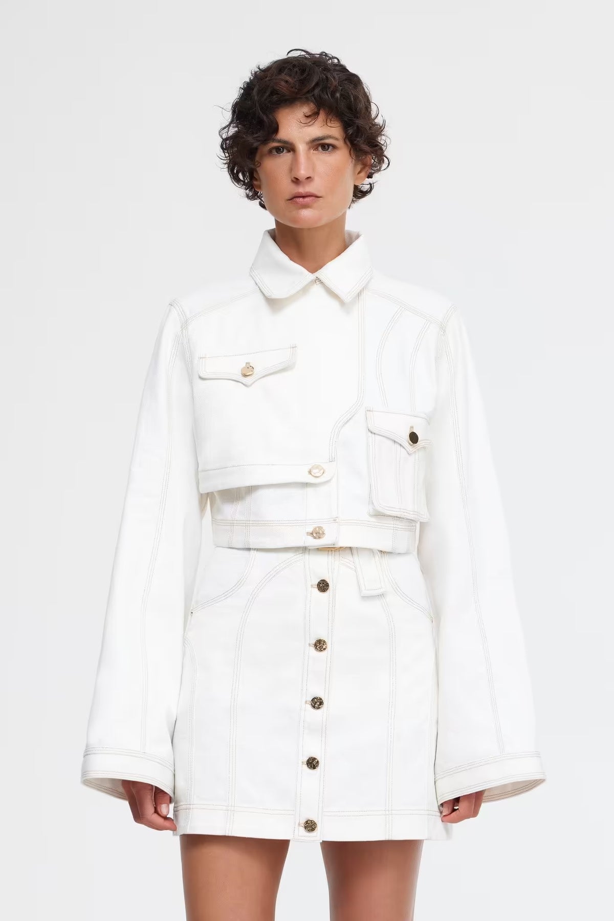 Ivory cropped jacket with pointed collar, flap pockets, and long sleeves