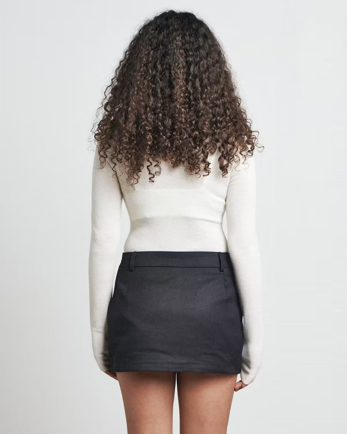 Black mini skirt with clean back view and straight hem