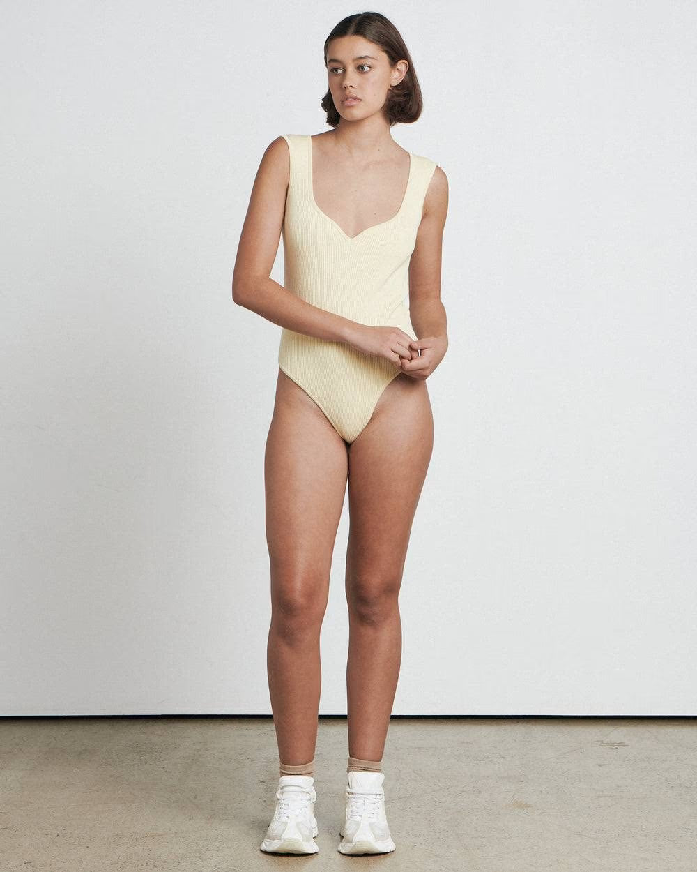 Butter sweetheart bodysuit, sleeveless deep V neckline and high-cut leg, standing