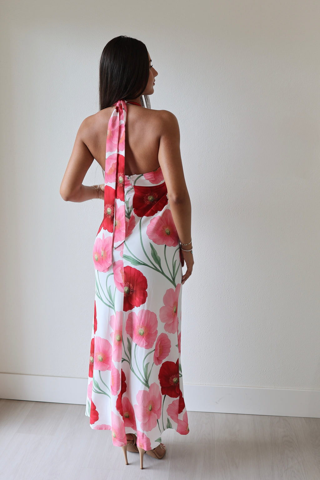 Back view of floral halter maxi dress with open back and red pink poppy print