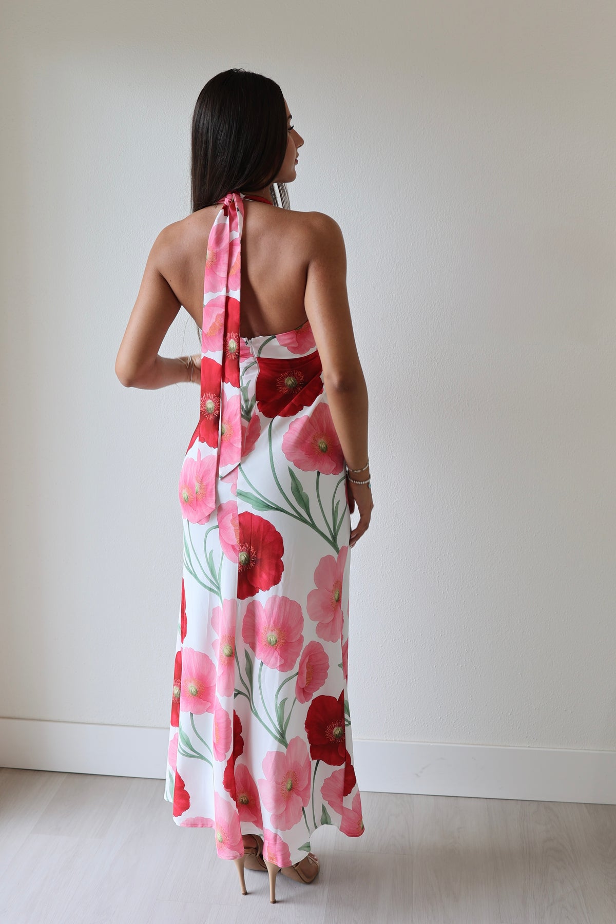 Back view of floral halter maxi dress with open back and red pink poppy print