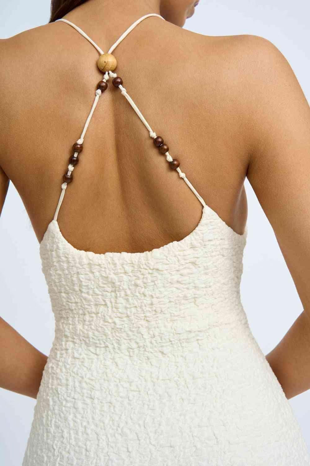 Ivory beaded midi dress with open back and thin crisscross straps with bead accents.