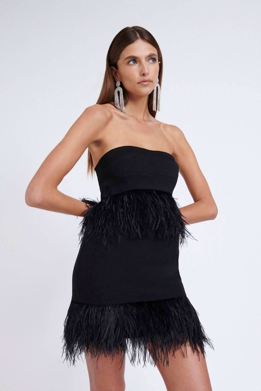Black strapless bustier mini dress with feather fringe skirt, side view