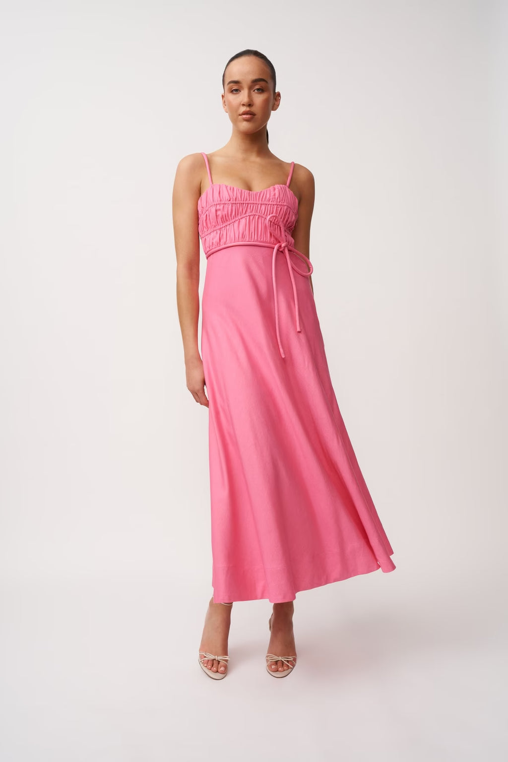Pink panel dress in midi length with square neckline, smocked bodice, and waist tie.