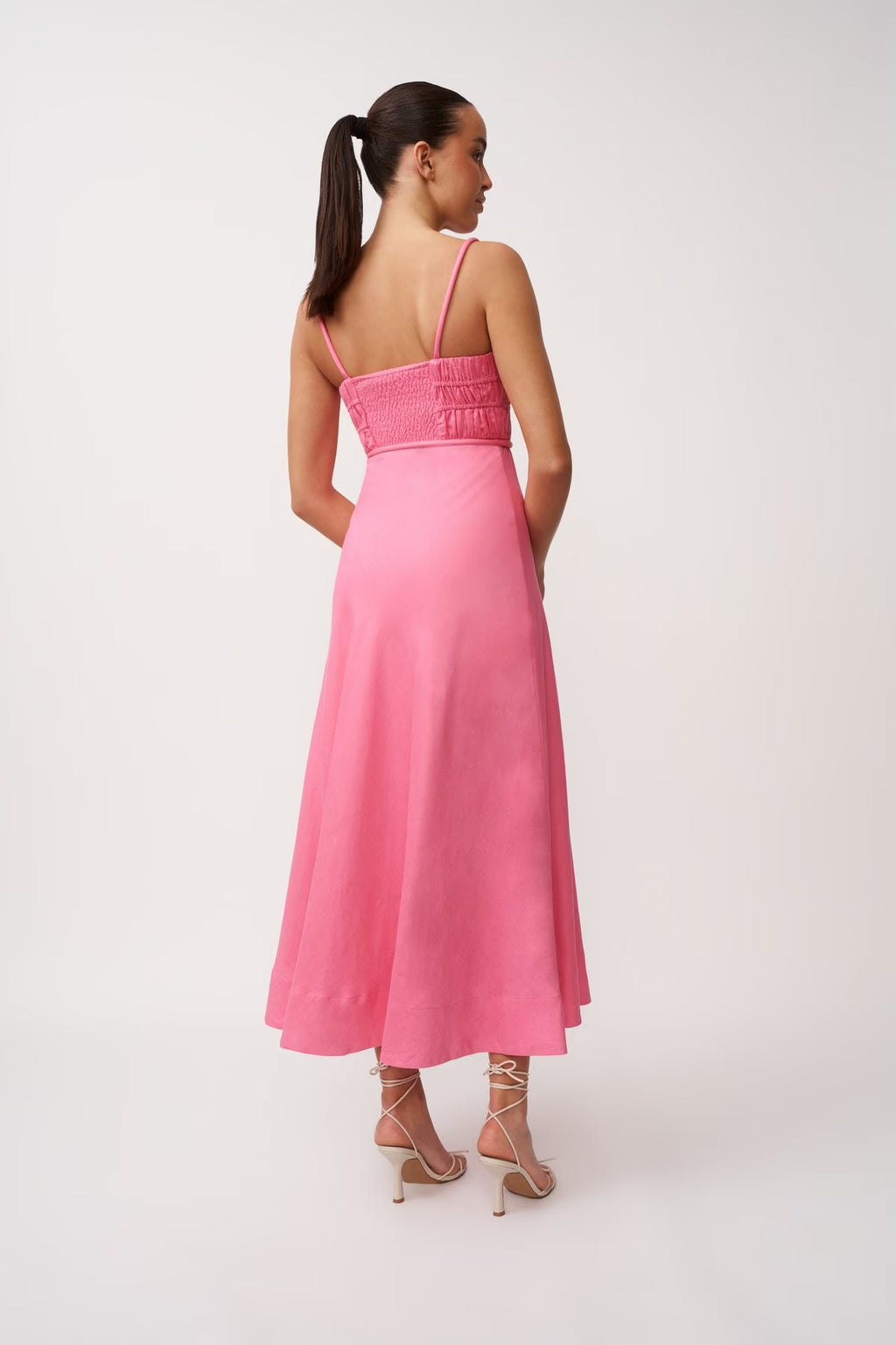 Back view of pink midi panel dress with spaghetti straps and gathered waist tie.