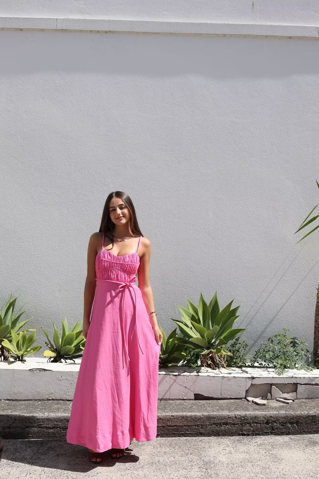 Pink midi panel dress with square neckline, gathered bodice, and tied waist, sleeveless.
