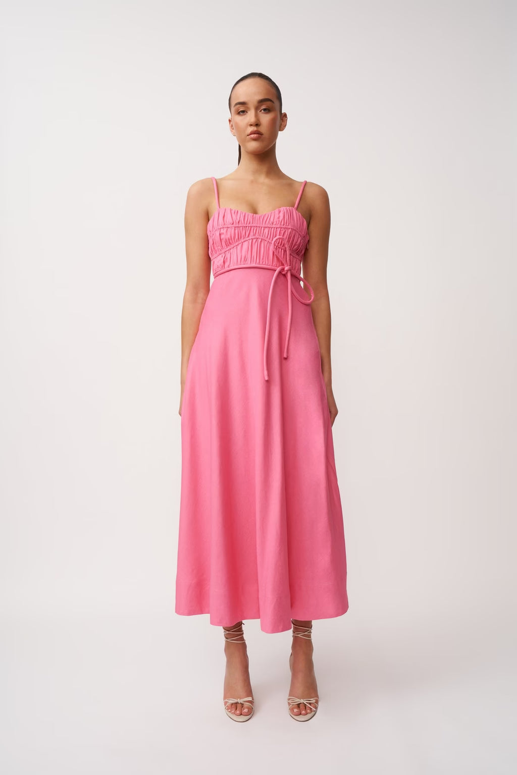 Pink midi panel dress, sleeveless with thin straps and gathered bust, tie belt at waist.