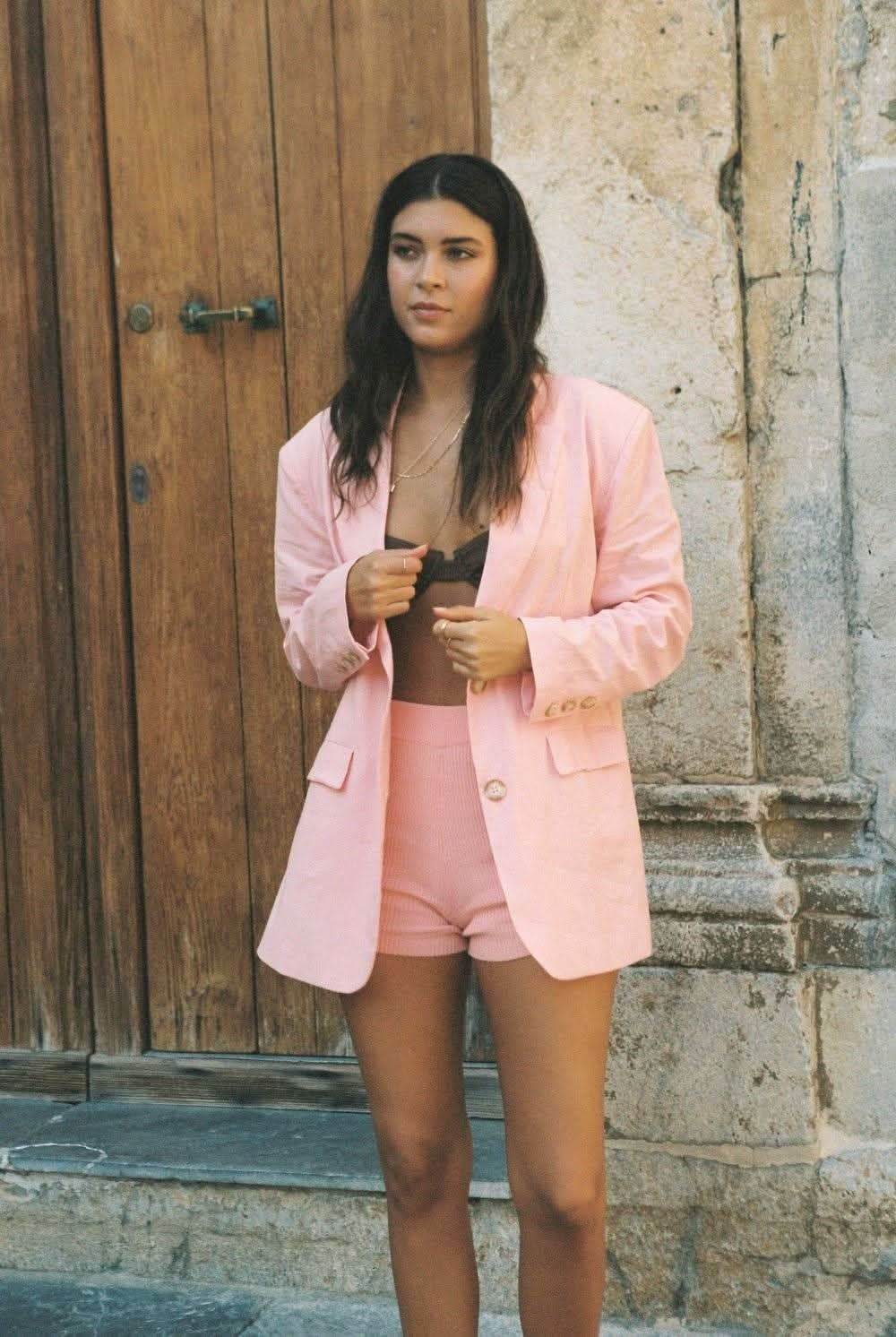 Pink blazer with notched lapels and gold buttons, long sleeves, tailored silhouette