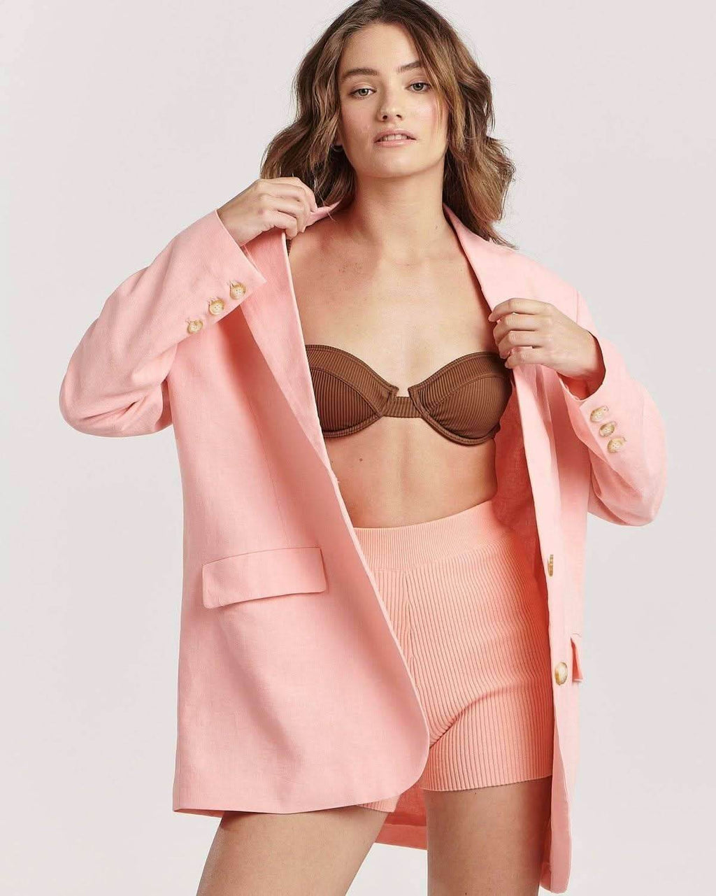 Pink blazer close-up: gold button cuffs, notched lapels, single-breasted front