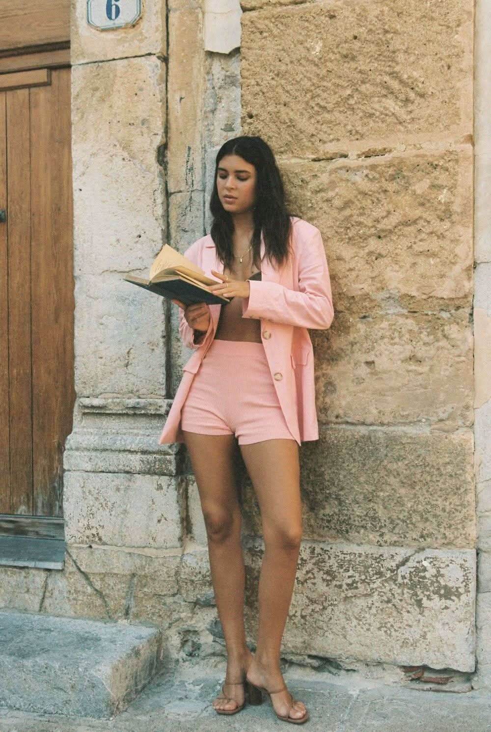 Pink blazer with notched lapels and gold button front, long sleeves, tailored fit