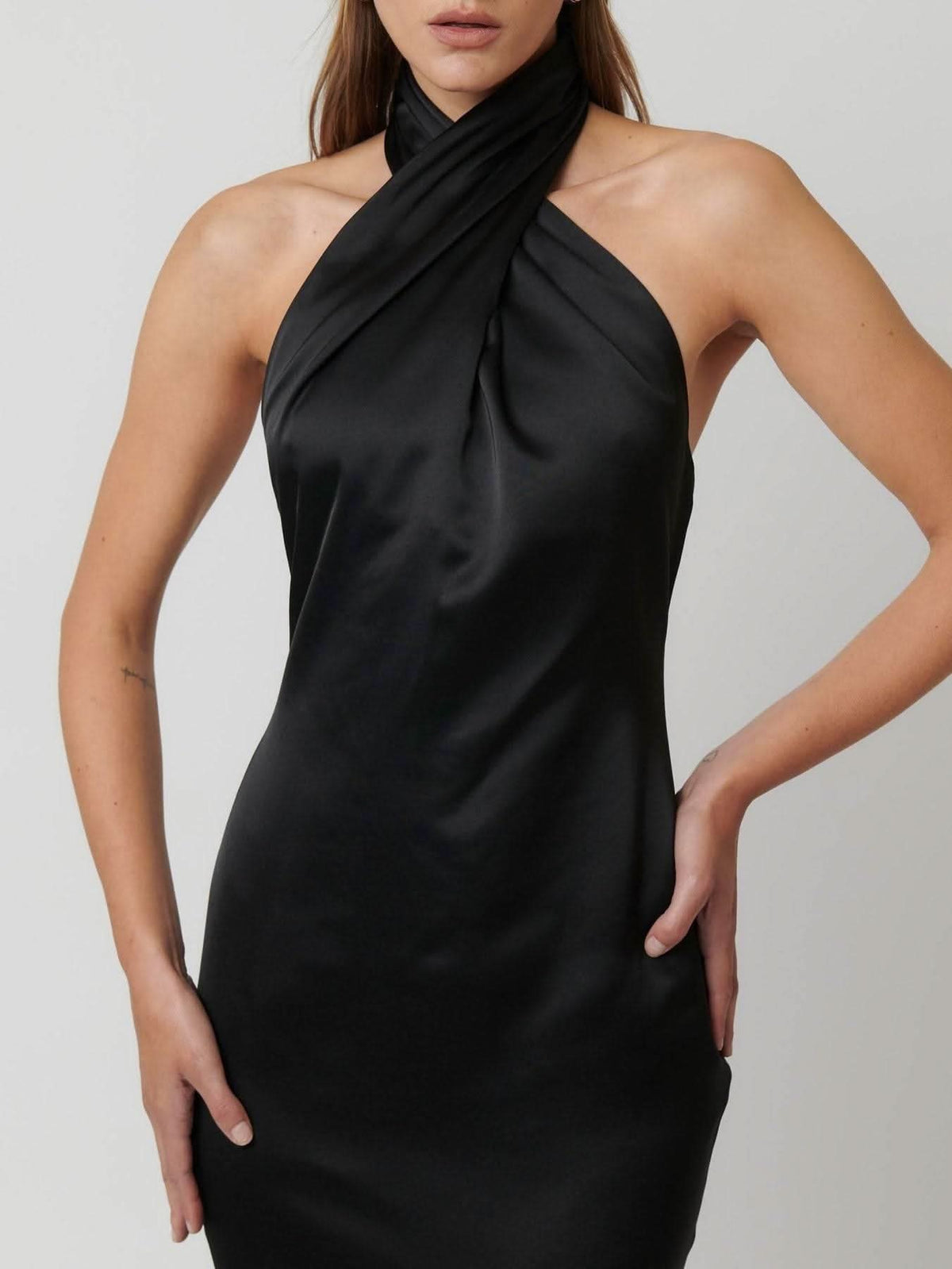Black satin halter gown with draped neck scarf and fitted bodice, side view