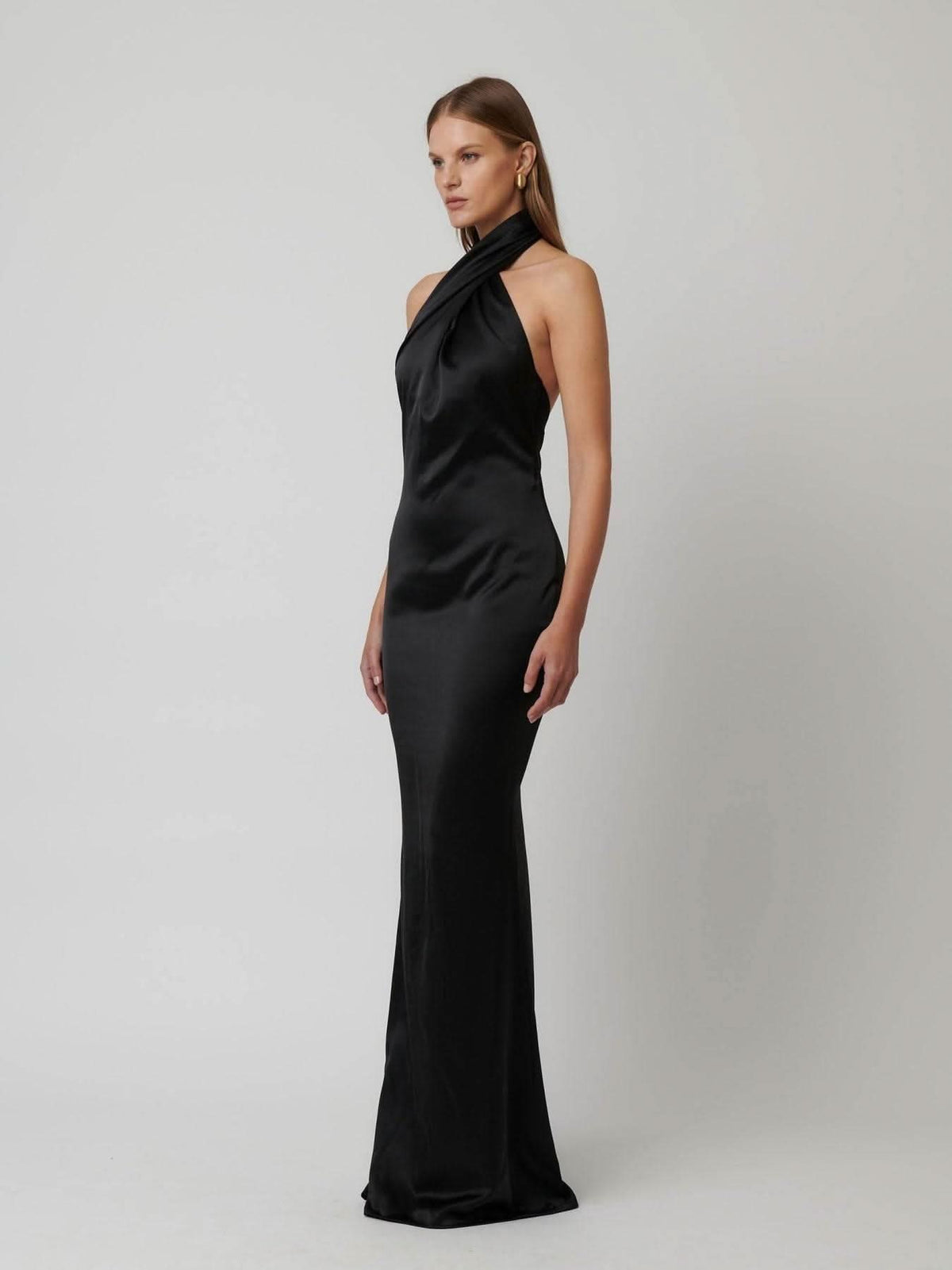 Black satin halter gown with draped cowl neckline and sleeveless fitted silhouette
