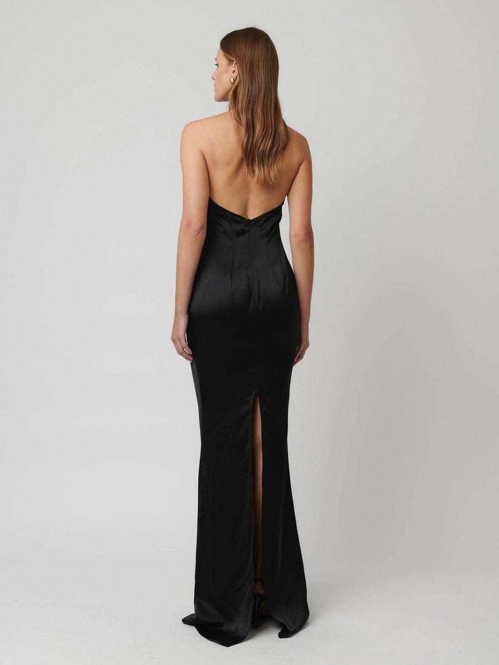Black satin halter gown with open back, slim straps, and floor-length front slit