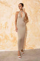 a woman in a beige Flook the Label Amoria Dress standing in front of a wall