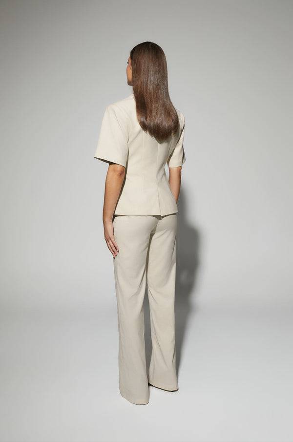 Light cream blazer back view, short sleeves, tailored waist and straight hem