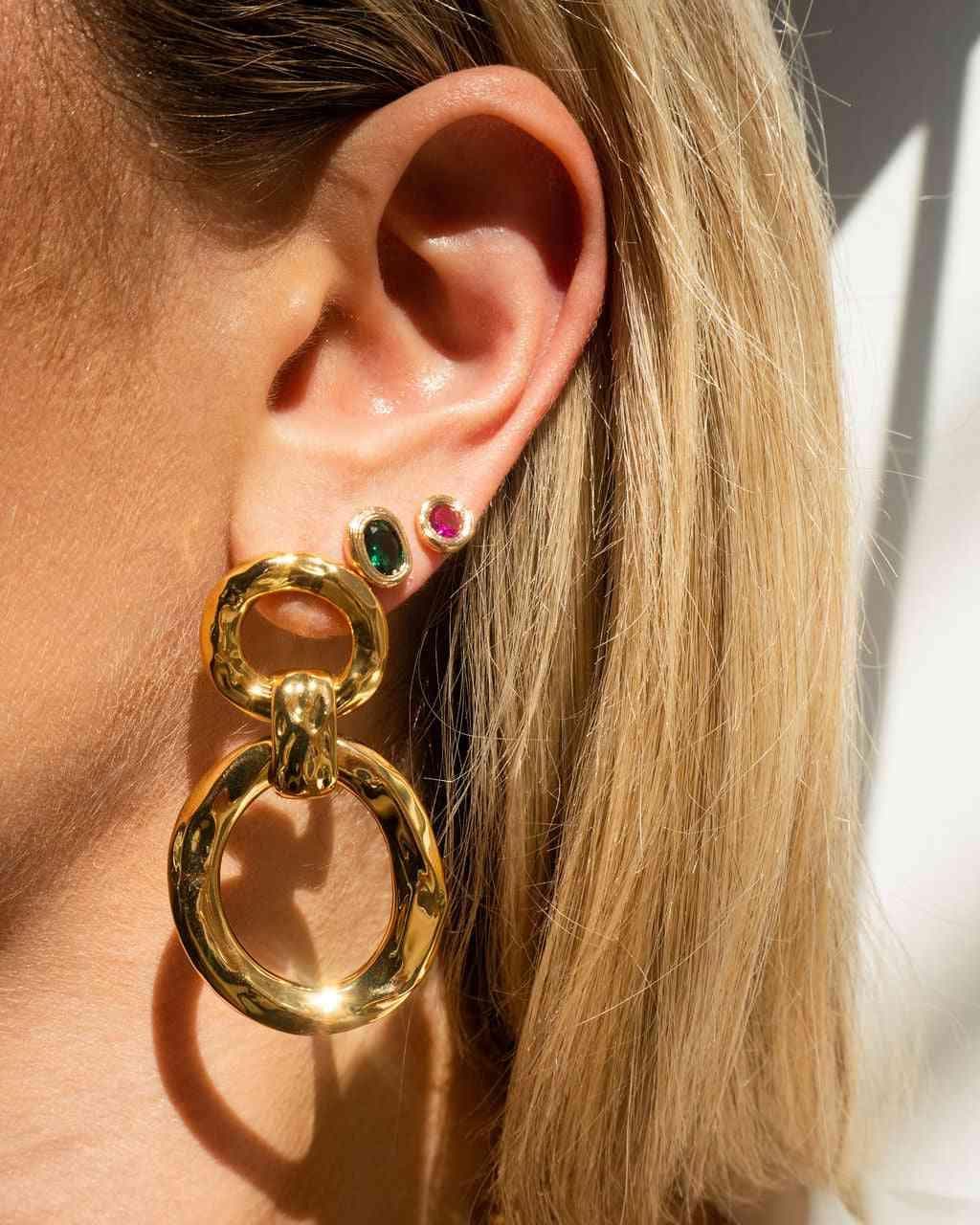 Gold hammered loop hoop earrings with layered rings and multi-color gemstone accents