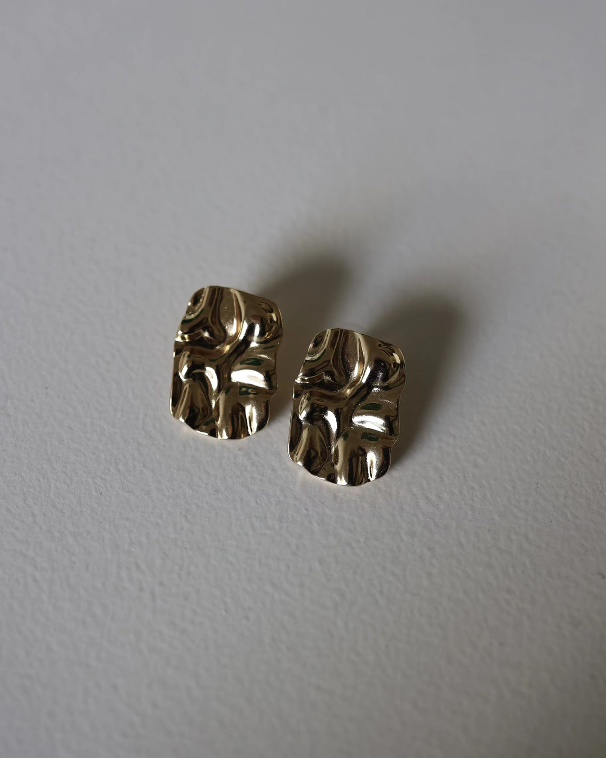 Close-up of gold textured square stud earrings