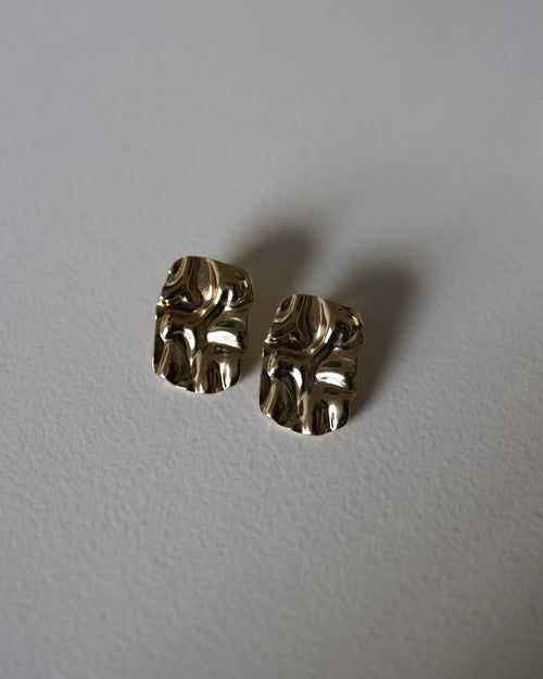 Close-up of gold textured square stud earrings