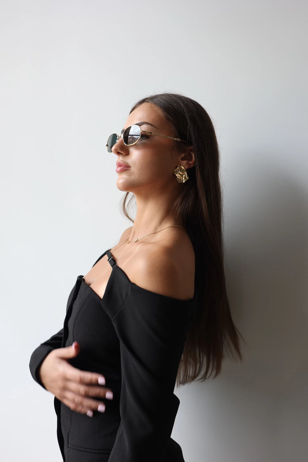 Gold textured square stud earrings worn by model, side profile view