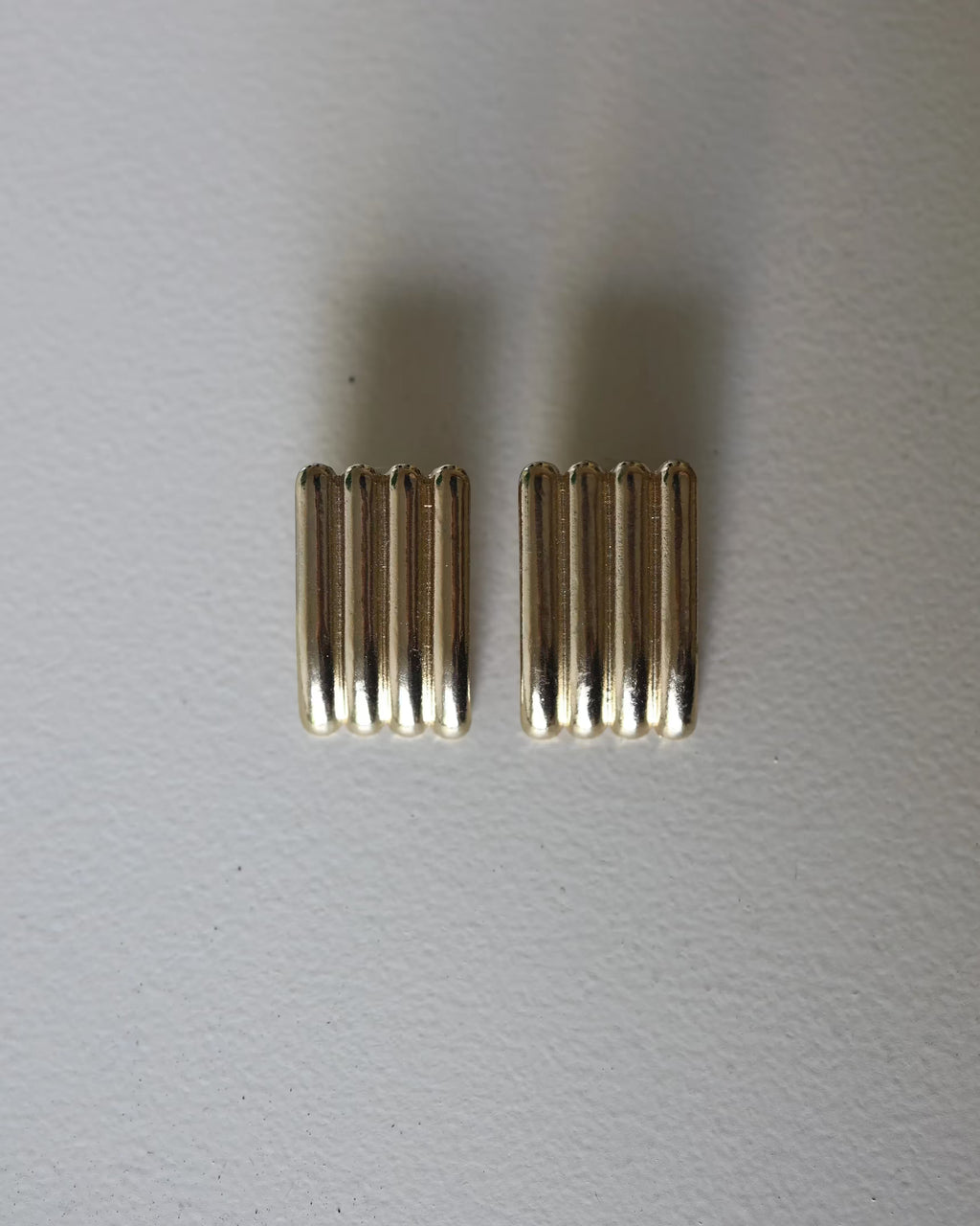 Gold ridged half-hoop earrings with vertical grooves, front view