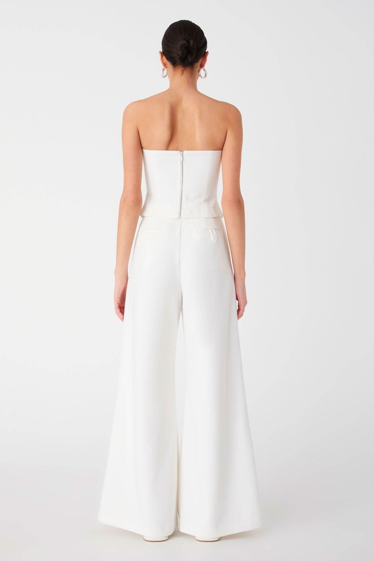 Ivory strapless top with open-back detail and wide-leg trousers, back view