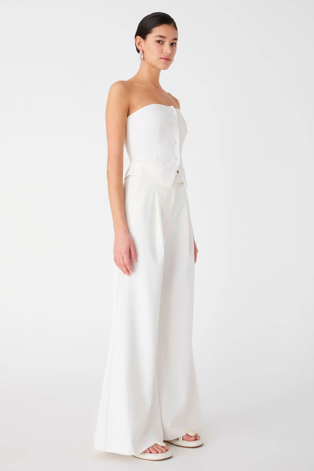 Ivory strapless top with layered peplum at waist and wide-leg trouser legs