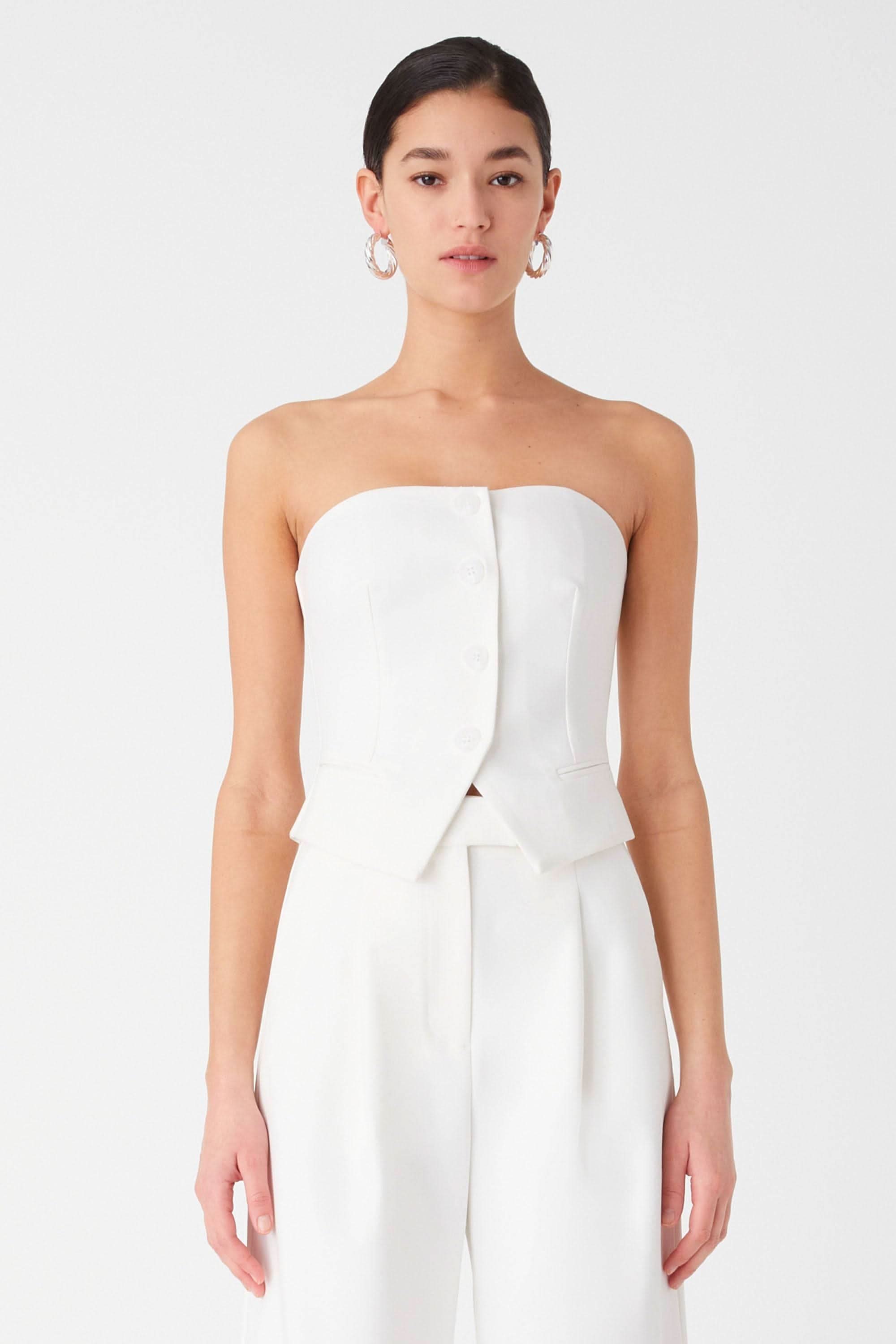 Ivory strapless top with tailored seams and peplum detail over wide-leg trousers