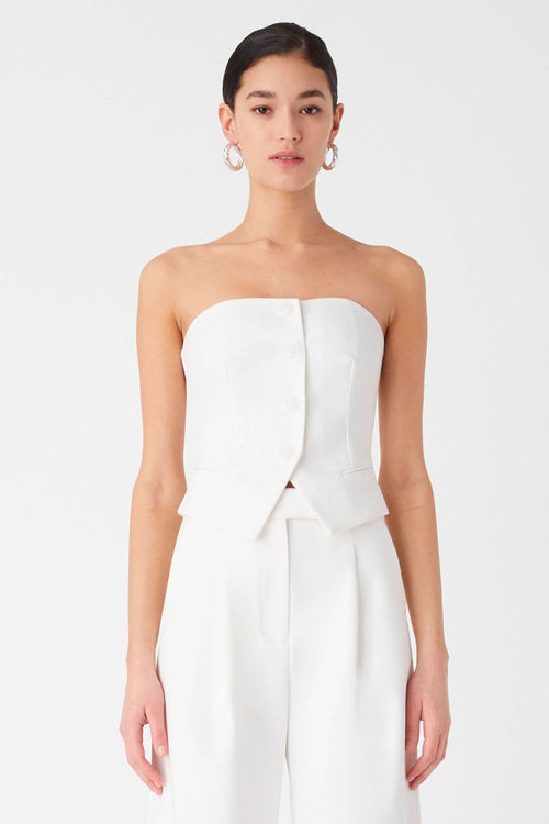Ivory strapless top with tailored seams and peplum detail over wide-leg trousers
