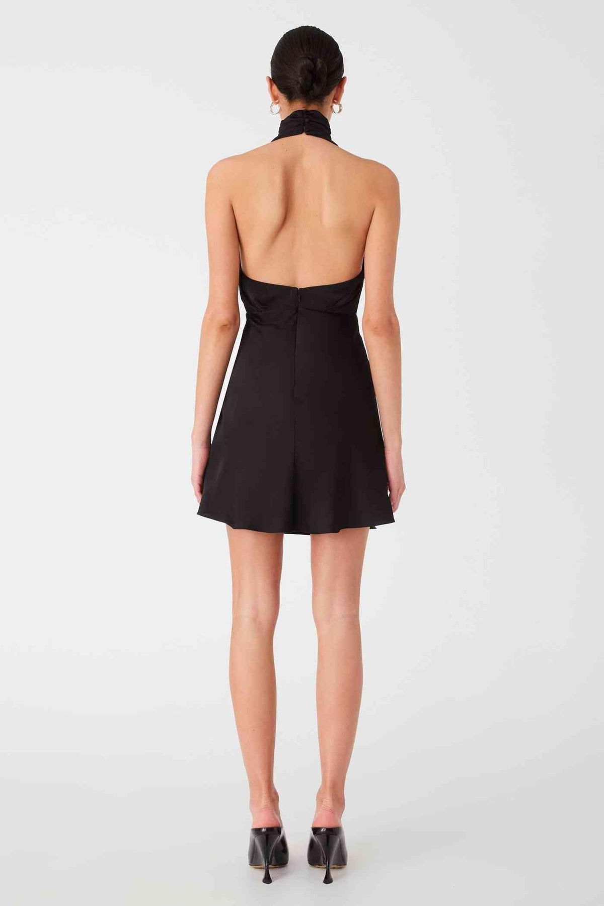 Black satin mini dress back view with halter straps and open-back design